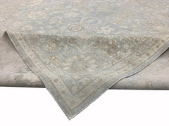 A handmade Afghan Balkh rug featuring a traditional floral pattern in soft blue and beige tones.