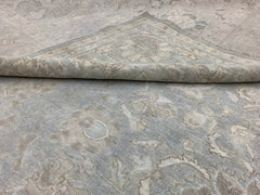 A handmade Afghan Balkh rug featuring a traditional floral pattern in soft blue and beige tones.