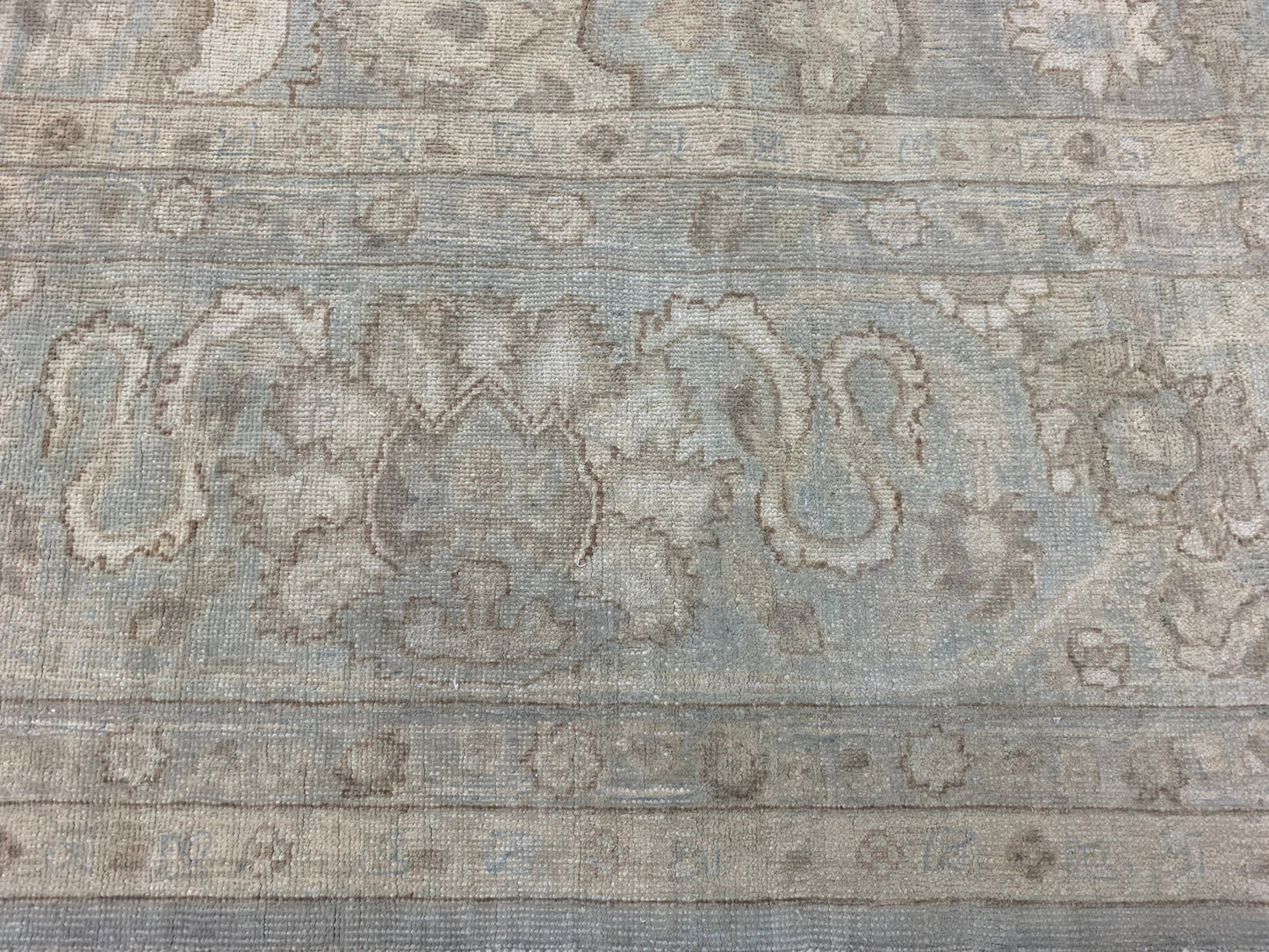 A handmade Afghan Balkh rug featuring traditional floral patterns in muted blue and beige tones.