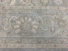 A handmade Afghan Balkh rug featuring traditional floral patterns in muted blue and beige tones.