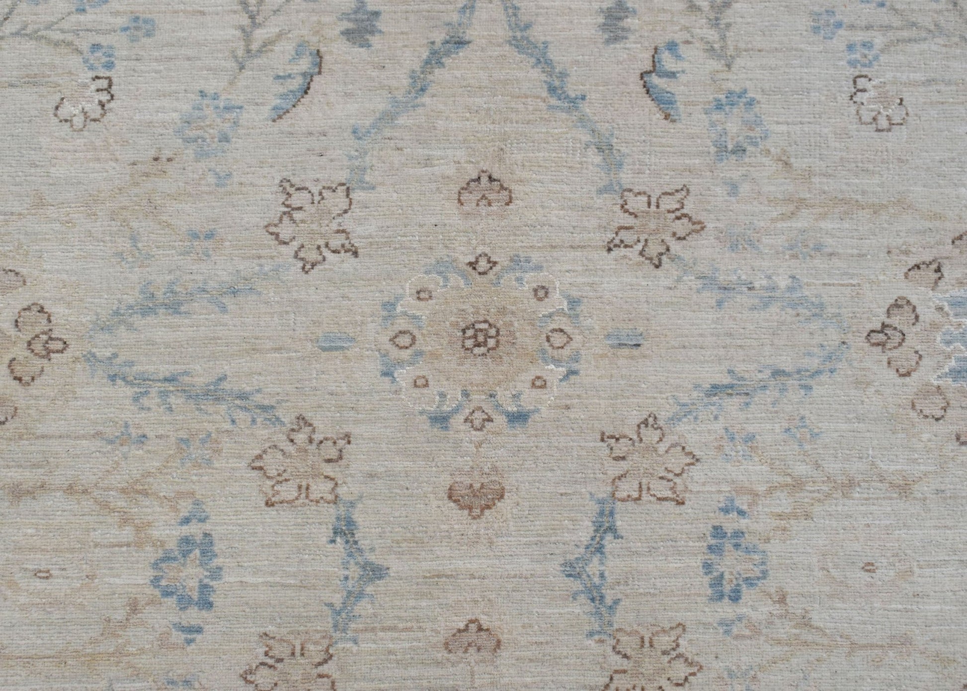 A handwoven Afghan Balkh rug featuring a traditional floral pattern in soft blue and beige tones.