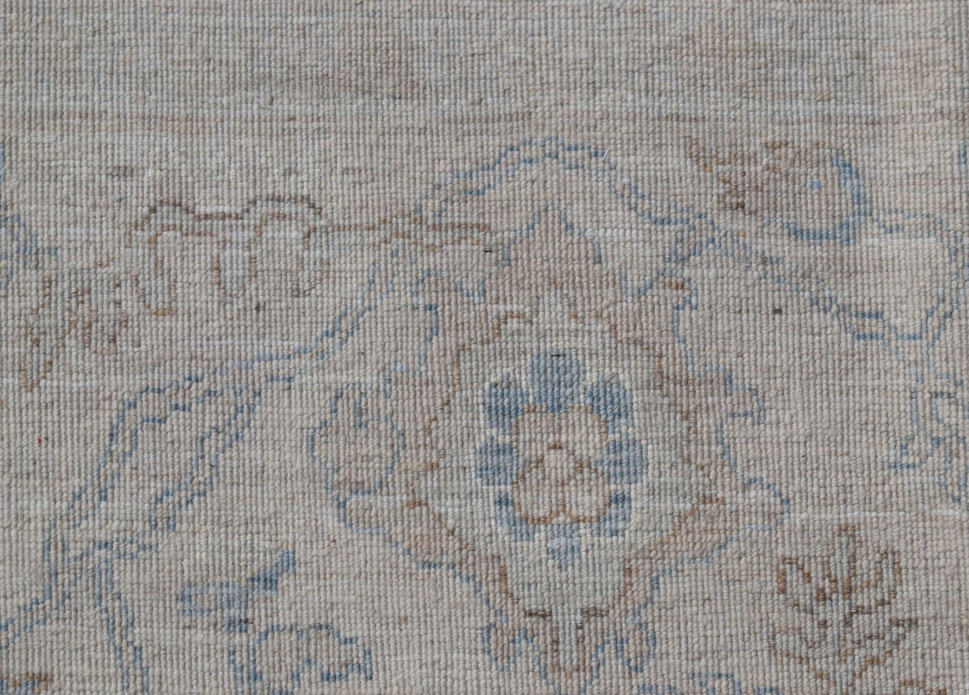 A handwoven Afghan Balkh rug featuring a traditional floral pattern in soft blue and beige tones.