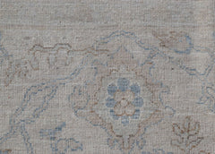 A handwoven Afghan Balkh rug featuring a traditional floral pattern in soft blue and beige tones.