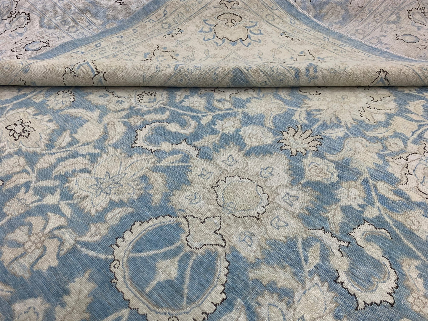 A handmade Afghan Balkh rug featuring a traditional floral pattern in shades of blue and cream.