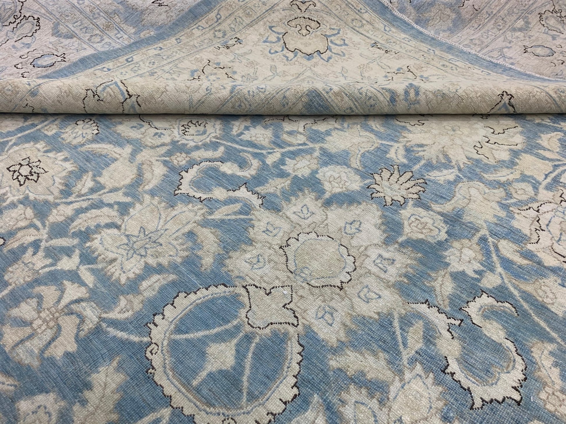 A handmade Afghan Balkh rug featuring a traditional floral pattern in shades of blue and cream.