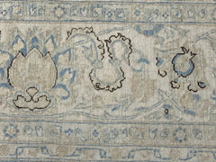 A close-up of an Afghan Balkh rug featuring intricate floral patterns in blue and beige tones.