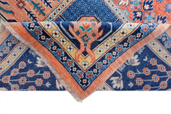 A handwoven Afghan Balkh rug featuring a blue field with floral patterns and a folded corner.