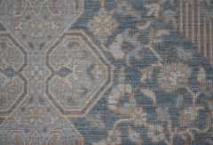 A handwoven Afghan Balkh rug featuring a traditional floral pattern in muted blue and beige tones.