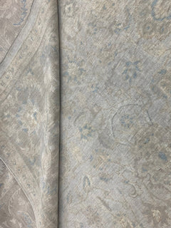 A handmade Afghan Balkh rug featuring a traditional floral pattern in soft beige and blue tones.