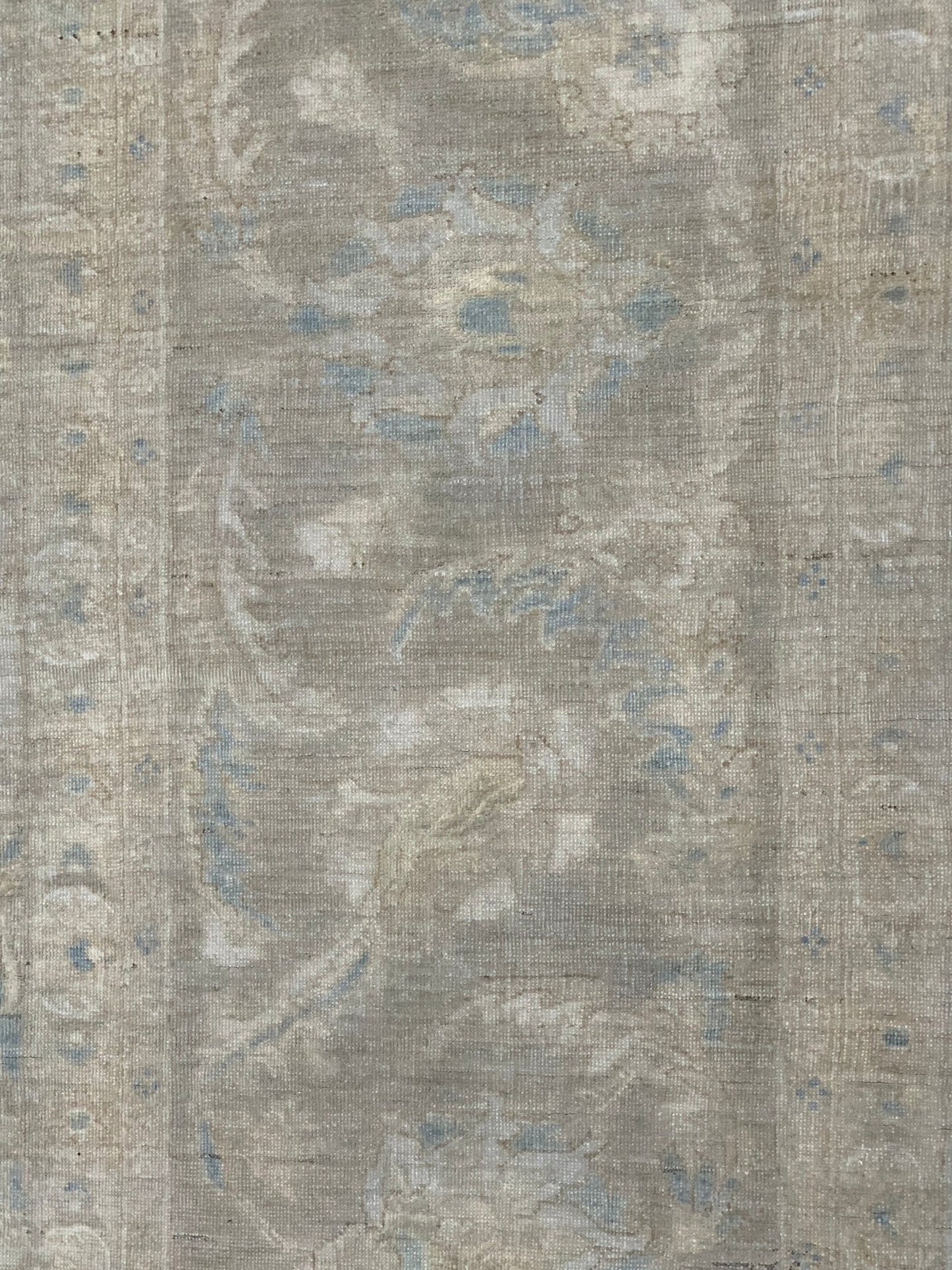 A handmade Afghan Balkh rug featuring a traditional floral pattern in muted grey and blue tones.
