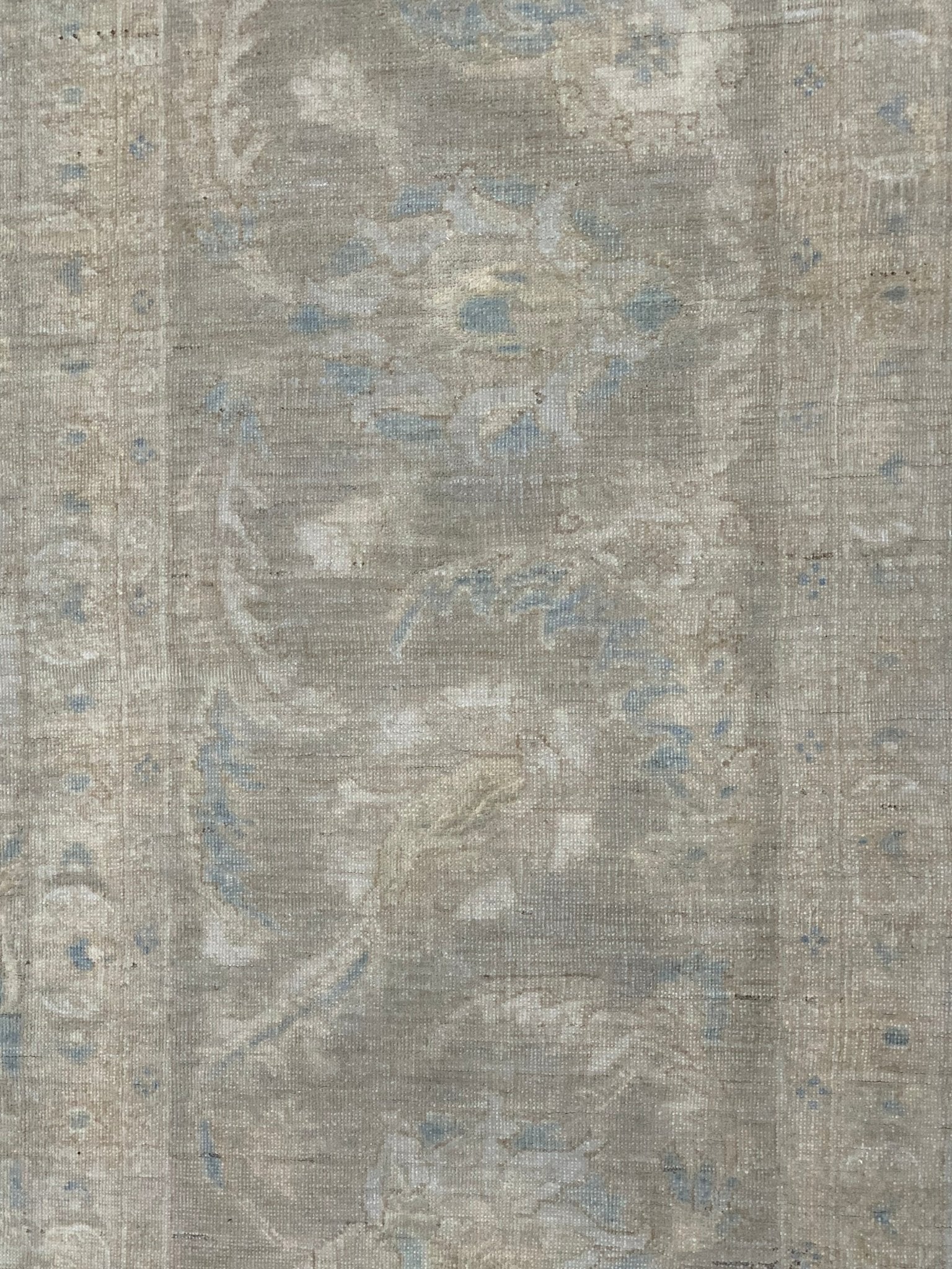 A handmade Afghan Balkh rug featuring a traditional floral pattern in muted grey and blue tones.