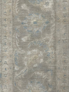 A handmade Afghan Balkh rug featuring a traditional floral pattern in muted grey and blue tones.