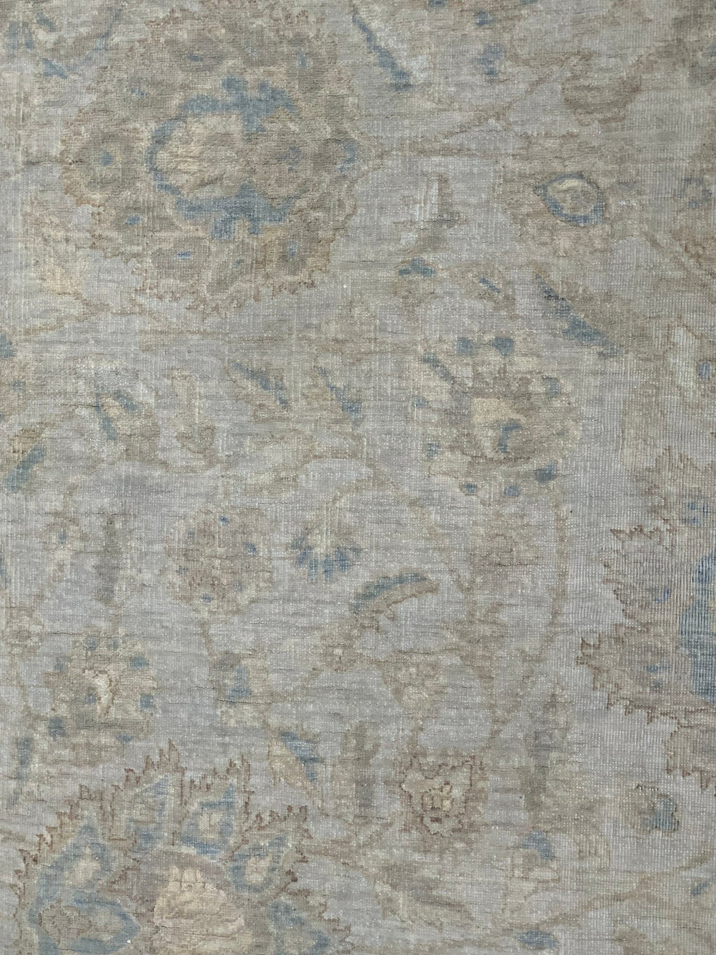 A handmade Afghan Balkh rug featuring a traditional floral pattern in muted blue and beige tones.