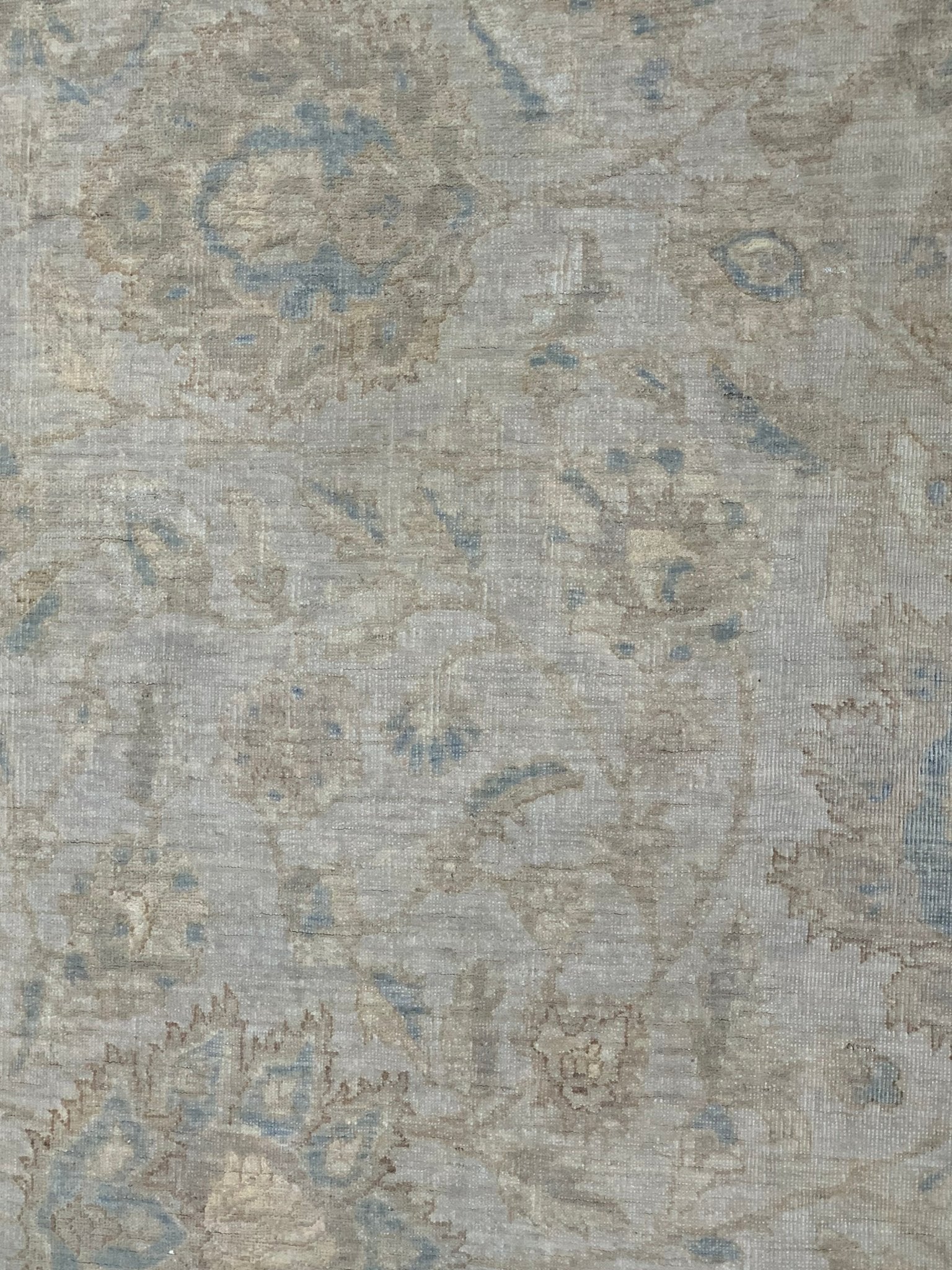 A handmade Afghan Balkh rug featuring a traditional floral pattern in muted blue and beige tones.