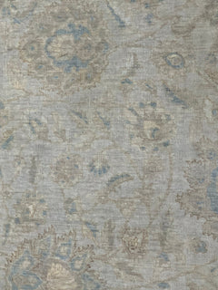 A handmade Afghan Balkh rug featuring a traditional floral pattern in muted blue and beige tones.