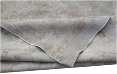 A handwoven Afghan Balkh rug featuring a traditional pattern in soft grey and beige tones.
