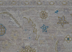 A handwoven Afghan Balkh rug featuring a light beige field with small blue and yellow star motifs.