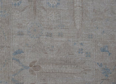 A handwoven Afghan Balkh rug featuring a subtle, traditional pattern in soft beige and blue tones.