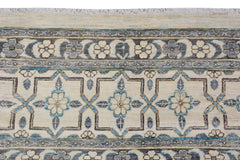 An Afghan Balkh rug featuring a cream field with blue and grey floral geometric patterns.