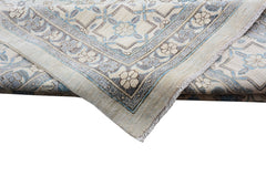A folded Afghan Balkh rug featuring a traditional floral pattern in soft blue and beige tones.
