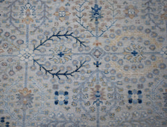 A handwoven Afghan Balkh rug featuring a traditional floral pattern in soft blue and beige tones.