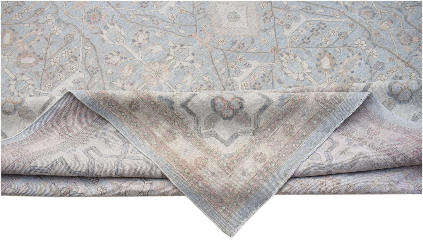 A handwoven Afghan Balkh rug featuring a traditional floral pattern in soft blue and beige tones.