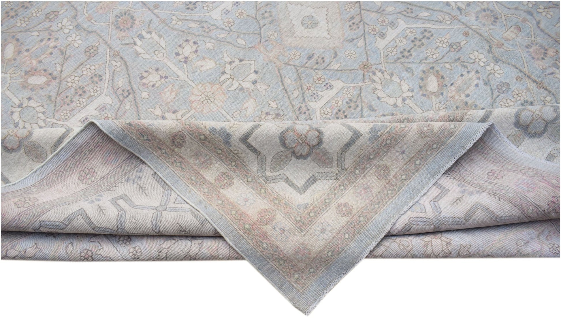 A handwoven Afghan Balkh rug featuring a traditional floral pattern in soft blue and beige tones.