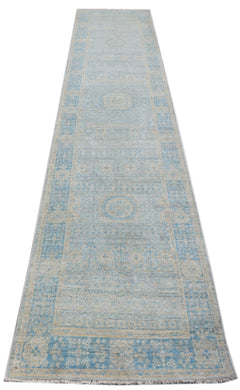 A handwoven Afghan Chobi runner rug featuring a light blue and beige Mamluk medallion pattern.