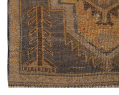 A handmade Afghan Baluch rug featuring a dark brown field with a stylized tree and geometric border.