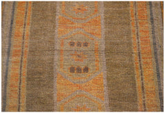 A handmade Afghan Baluch rug featuring geometric patterns in shades of brown and orange.