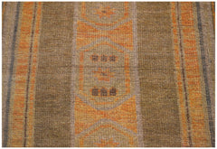 Handmade Afghan Baluch rug featuring geometric patterns in shades of brown and orange.
