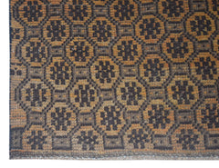 Handmade Afghan Baluch rug featuring a repeating geometric floral pattern in brown and tan wool.