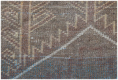 A close-up of a handmade Afghan Baluch rug featuring geometric patterns in brown, blue, and cream.