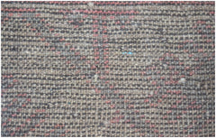 A close-up of a handmade Afghan Baluch rug featuring a textured, geometric pattern in wool.