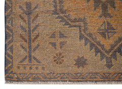 A handmade Afghan Baluch rug featuring geometric patterns in shades of brown and orange.