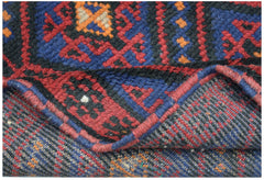 A handmade Afghan Baluch rug featuring a geometric pattern in deep red, blue, and orange wool.