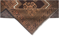 A handmade Afghan Baluch wool rug featuring geometric patterns in shades of brown.