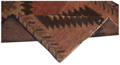 A handmade Afghan Baluch rug featuring a geometric pattern in shades of brown and red.