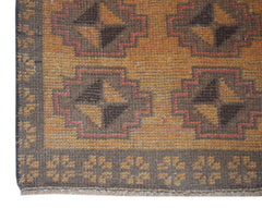 Handmade Afghan Baluch rug featuring a geometric pattern in shades of brown and gold.