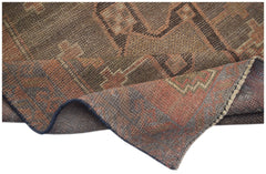 A handmade Afghan Baluch wool rug featuring geometric patterns in shades of brown and rust.