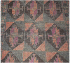 Handmade Afghan Baluch rug featuring a repeating geometric diamond pattern in dark wool tones.