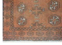 Handmade Afghan Baluch rug featuring geometric motifs in shades of orange and dark brown.