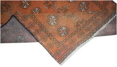 Handmade Afghan Baluch rug featuring a geometric pattern in shades of orange and dark brown.