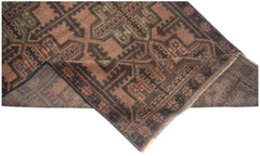 A handmade Afghan Baluch rug featuring a geometric pattern in shades of brown, rust, and green.