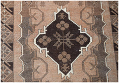 Handmade Afghan Baluch rug featuring a dark brown central medallion with floral motifs on tan wool.