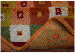 A handmade Afghan Baluch rug featuring a geometric grid pattern in warm earth tones.