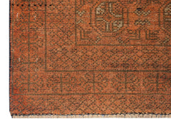 A close-up of a handmade Afghan Baluch rug featuring a geometric pattern in shades of orange.