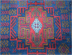 Handmade Afghan Baluch rug featuring a geometric tribal pattern in red, blue, and brown wool.
