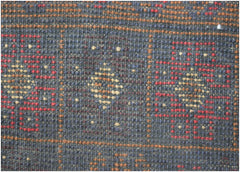 A handmade Afghan Baluch rug featuring a geometric pattern in dark red, blue, and ivory wool.