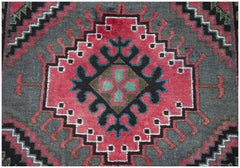 Handmade Afghan Baluch rug featuring a central geometric diamond motif in pink, black, and teal.